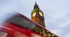 A red bus passes Big Ben in London.