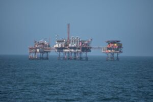 A group of oil rigs in a large body of water.